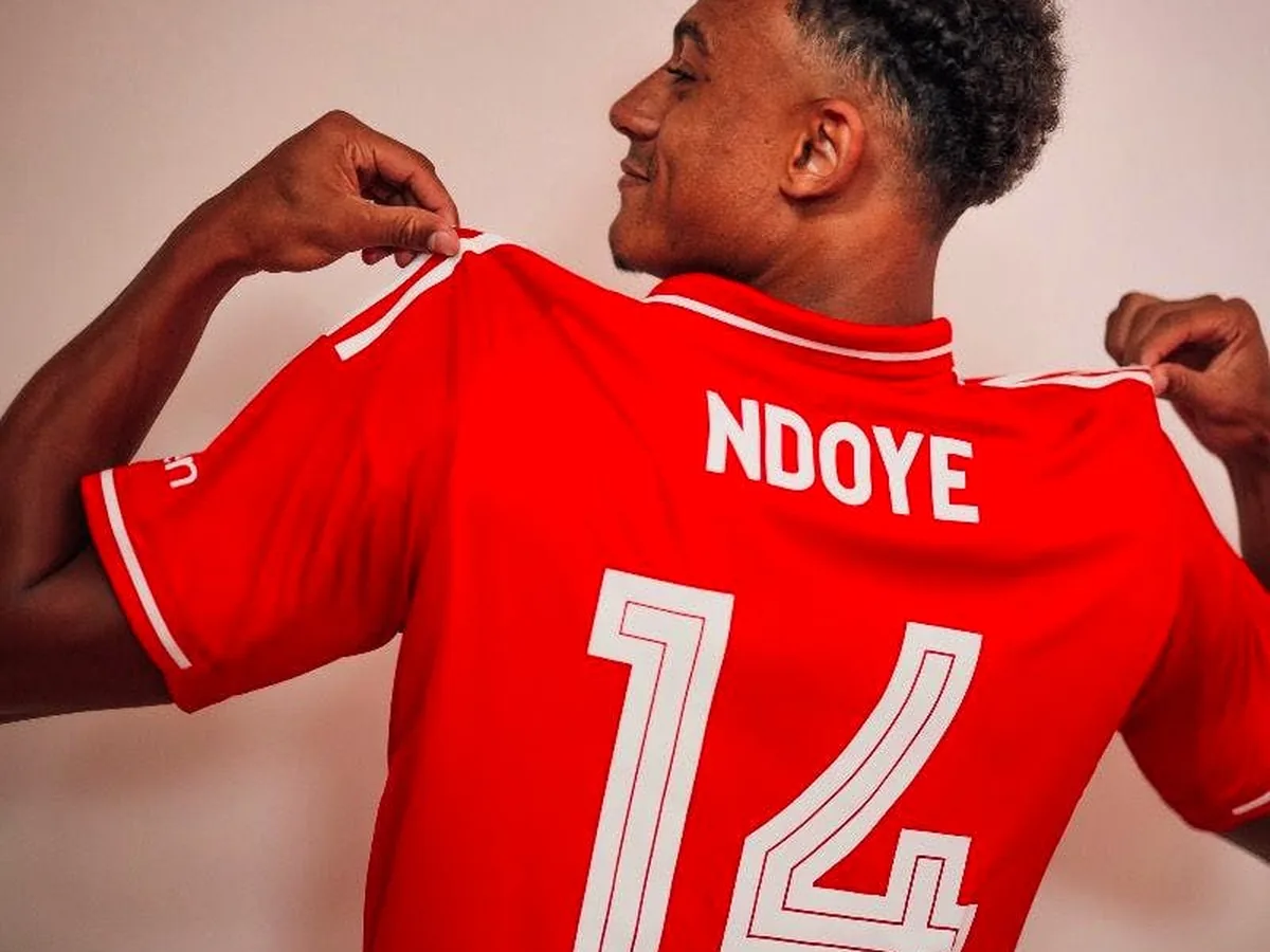 Dan Ndoye tenant son maillot rouge floqu&eacute; &laquo;&nbsp;Ndoye 14&nbsp;&raquo; de Nottingham Forest, vu de dos par-dessus l&rsquo;&eacute;paule.