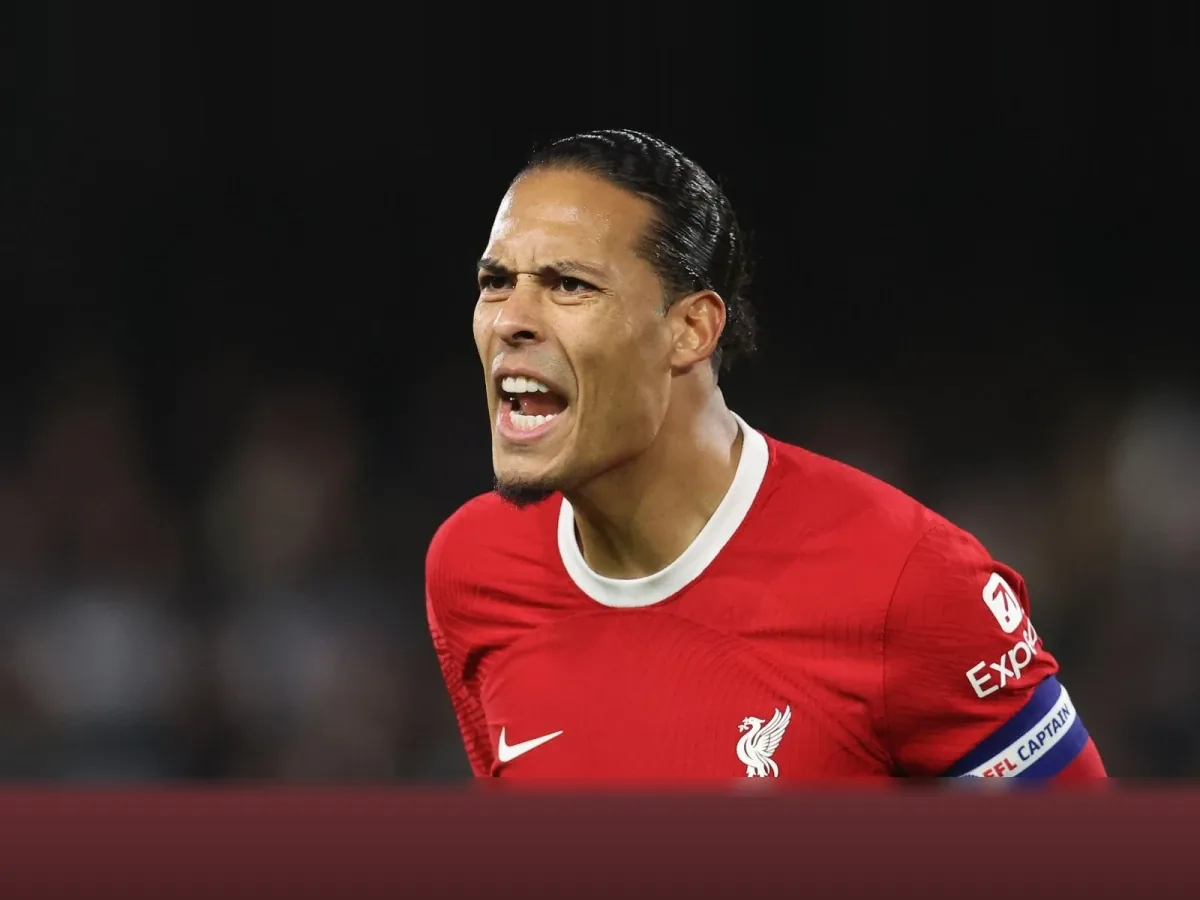Virgil van Dijk criant, brassard de capitaine au bras, en maillot rouge de Liverpool.